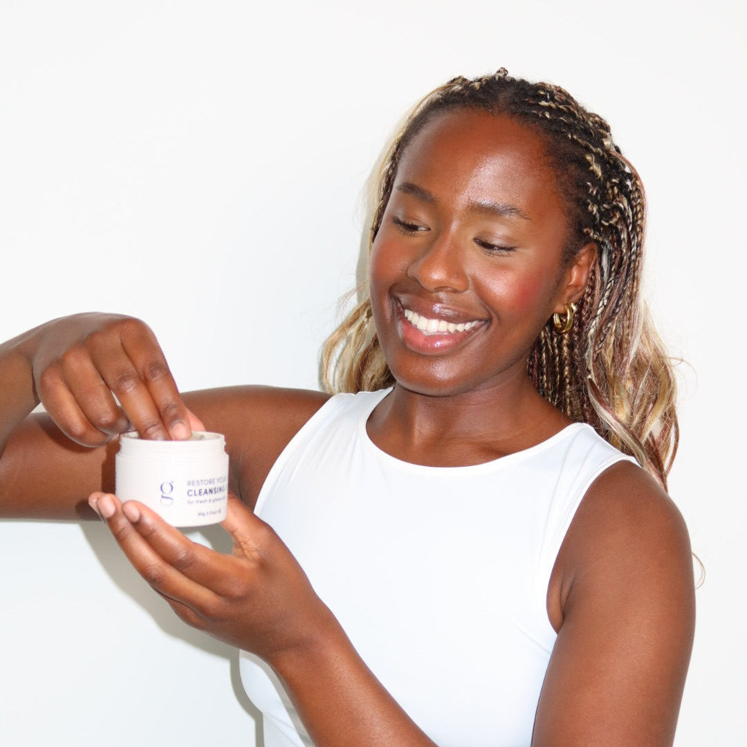 Woman holding a skincare product against a white background
